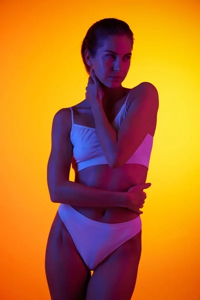 Portret Pięknej Kobiety Pozującej Bieliźnie Pomarańczowym Tle Studia Neonowym Świetle — Zdjęcie stockowe