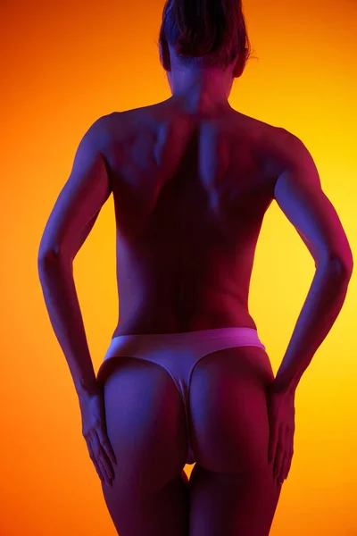 Porträt Einer Frau Unterwäsche Mit Nacktem Rücken Auf Orangefarbenem Hintergrund — Stockfoto