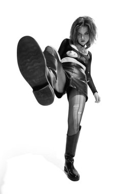 Portrait of young expressive woman, rock music lover posing in leather clothes over white background. Black and white. Concept of music, rock and roll, lifestyle, fashion. Copy space for ad, text clipart