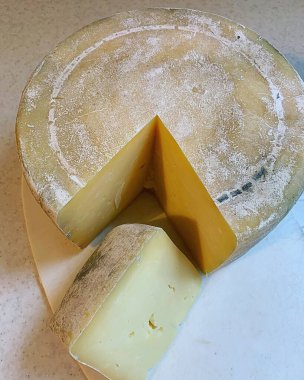 Doğal olgunlaştırıcı peynir, doğal kabuklu peynir, ahşap bir tahtanın üzerinde ev yapımı peynir, inek sütü ürünü, geleneksel ev yapımı yemek, rennet peyniri.