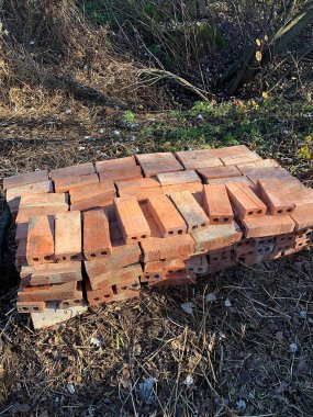 Yere yığılmış turuncu tuğlalar, bahçede tuğlalar, inşaat hazırlıkları, inşaat malzemeleri, dikdörtgen tuğlalar.