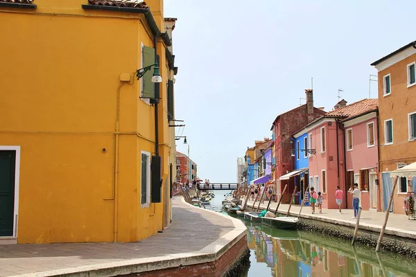 small colourful houses by a water channel, Italian town of Chioggia, colourful buildings, narrow water channel between houses, low water level