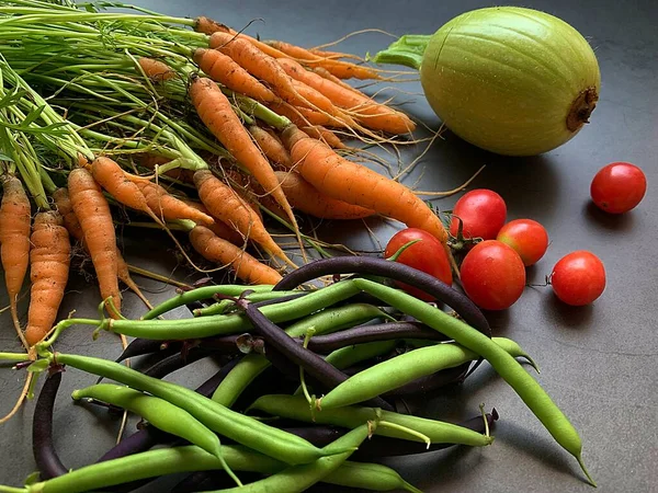 small carrots, green and purple green beans, round courgette, small tomatoes, harvest from the garden, allotment produce, healthy vegetables, carrots with green tails
