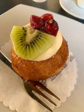 Üstünde meyveli kek, tatlı, krema, kivi dilimi ve yabani çilek, yumuşak kek, tatlı