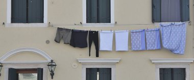 İpte asılı giysiler, evin ön cephesinde yıkanmak, kepenkler ve asılı kıyafetler, klasik yıkama manzarası.