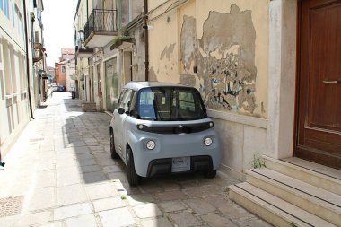 Dar bir caddeye park edilmiş küçük bir araba kalabalık şehirler için düzgün bir araba kolay park için araba, gri araba, modern küçük araba modeli