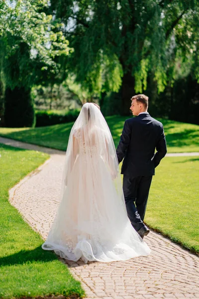 Gelin ve damat parkta el ele yürürler..