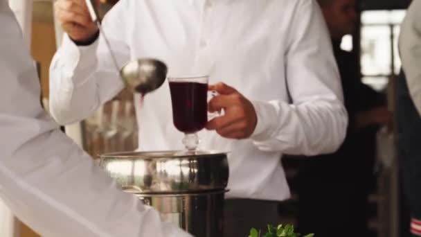 ホット・モルドワインをグラスに注ぐ男だ。暖かい飲み物 — ストック動画