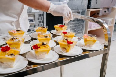 Yemek servisi. Garson masaya kremenki koyuyor ve süslüyor.. 