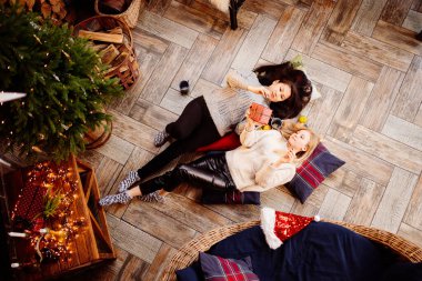 Üst Manzara. Yeni yıl süslemelerinde şöminede neşeli kız arkadaşlar