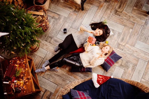 Üst Manzara. Yeni yıl süslemelerinde şöminede neşeli kız arkadaşlar