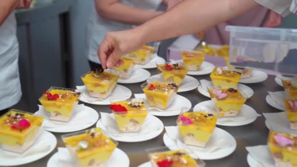 Catering. el camarero pone en la mesa kremenki con el postre y adorna. — Vídeos de Stock