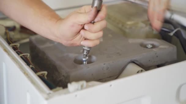 Naprawiający naprawia pralkę.. — Wideo stockowe