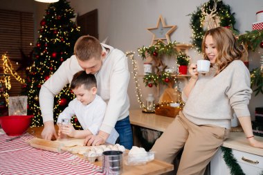 Mutlu aile geleneksel yemekleri yeni yıl hamurundan hazırlar. Annem hamile.