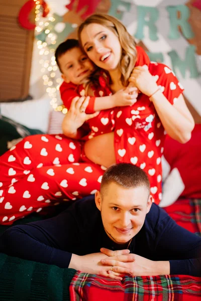 Όμορφη ευτυχισμένη οικογένεια με πιτζάμες στο κρεβάτι της νέας χρονιάς. — Φωτογραφία Αρχείου