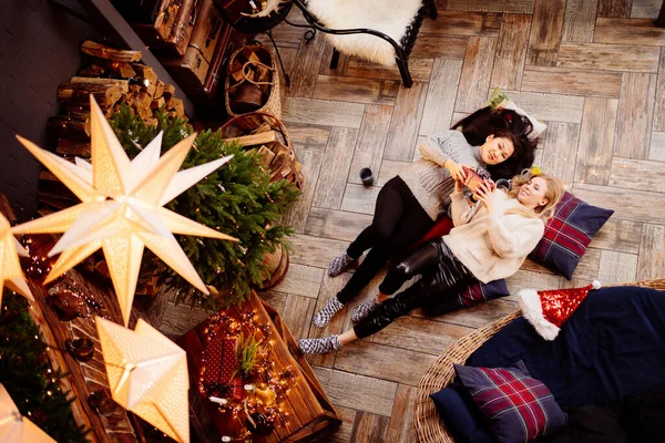 Üst Manzara. Yeni yıl süslemelerinde şöminede neşeli kız arkadaşlar