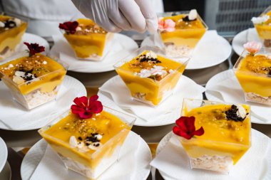 Yemek servisi. Garson masaya kremenki koyuyor ve süslüyor.. 