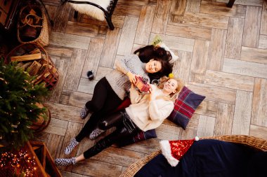 Üst Manzara. Yeni yıl süslemelerinde şöminede neşeli kız arkadaşlar