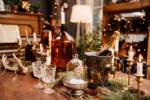 Vánoční dřevěný stůl s brýlemi, svíčkami a šampaňským. — Stock fotografie