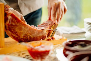 Eldivenli bir adam ziyafet için ince kuru et parçaları keser.. 