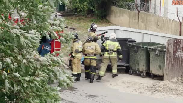 Brandweerlieden blussen een brandende vuilnisbak. hooliganisme — Stockvideo