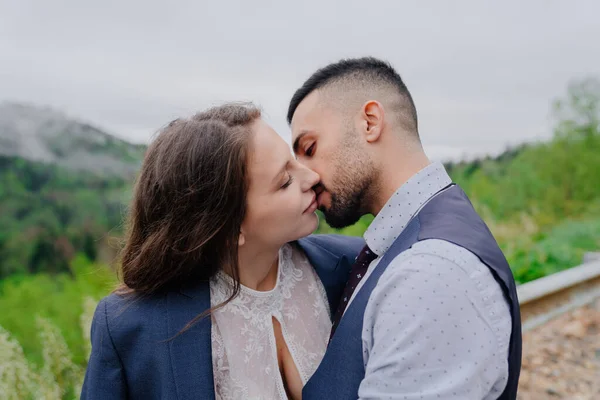 Braut und Bräutigam küssen sich zärtlich in der Natur. Romantik in der Beziehung — Stockfoto