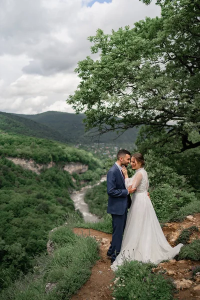 Une belle étreinte jeunes mariés dans une cérémonie de mariage dans les montagnes — Photo
