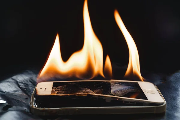 Siyah arkaplanda bozuk akıllı telefon yakmak. 