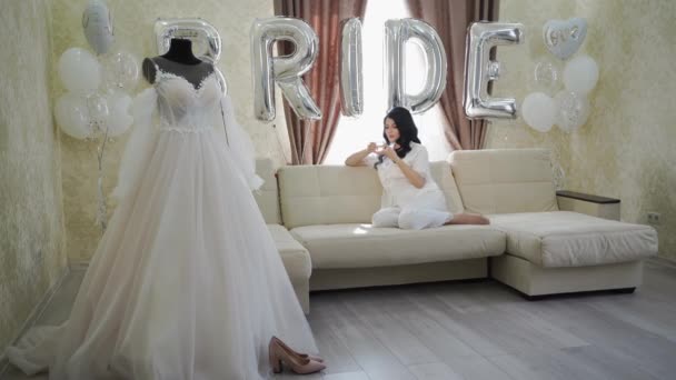 Morning of the bride. a beautiful young woman in white pajamas drinking tea. — Stock Video