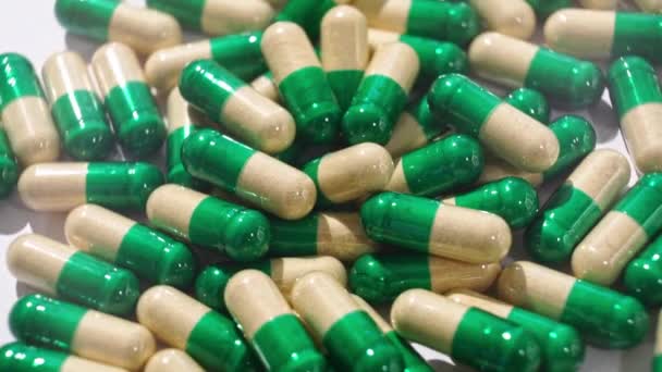 Draaiende geel-groene medicijnen pillen en capsules. achtergrond — Stockvideo