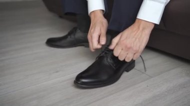 Bir erkek siyah ayakkabıları bağcıkla bağlar. Erkek modası. iş biçimi.