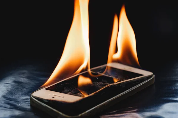 Siyah arkaplanda bozuk akıllı telefon yakmak. 