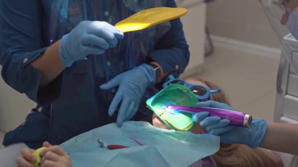 Dentist shows in the mirror the cured tooth. Cofferdam for treatment tooth — Stock Video
