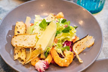 Gri tabakta karidesli salata. Deniz ürünleri yemeği. Restoranda menü.