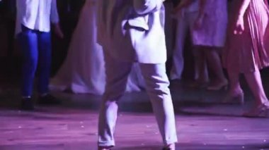 Beyaz takım elbiseli, dans eden bir kadının alt kısmı.. 