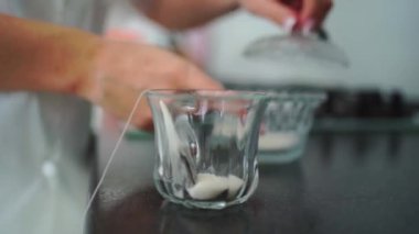 Kadın bir fincana şeker ve çay poşeti koyar ve sıcak su döker. Çay demliyorum.. 