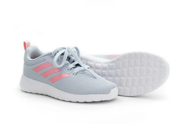 Sidovy. grå sport sneakers med rosa ränder på en vit bakgrund. adidas — Stockfoto