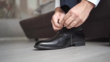 Bir erkek siyah ayakkabıları bağcıkla bağlar. Erkek modası. iş biçimi.