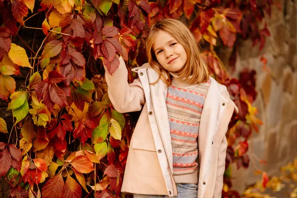 Nettes kleines Mädchen an der Wand mit herbstlichen wilden Trauben. Schönheit der herbstlichen Natur. — Stockfoto