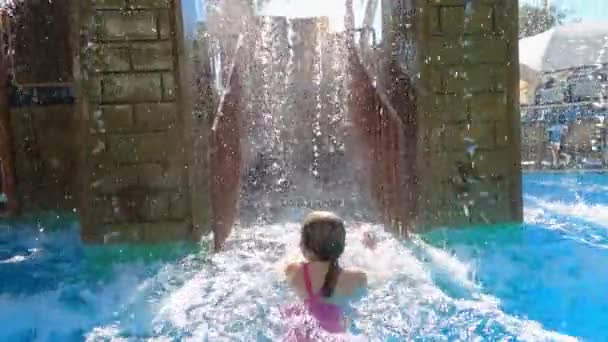 Девушка в розовом купальнике понятна по лестнице к водной горке — стоковое видео