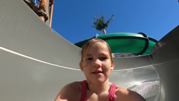Mädchen rollt Rutsche im Wasserpark hinunter. Junge kracht in ihren Rücken. Sicherheitsverstoß — Stockvideo
