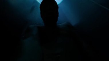 Elinde kamera olan bir adam su parkında bir kaydırağın üzerinde yuvarlanıyor.. 