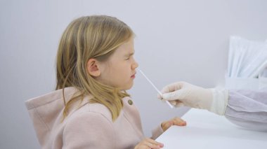 Küçük bir kıza koronavirüs enfeksiyonu için PCR testi yapılır.. 