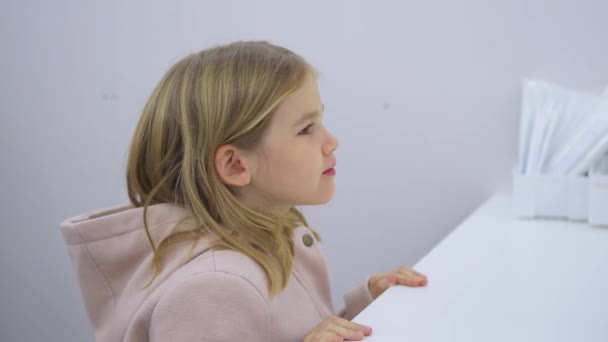 Une petite fille reçoit un test PCR pour l'infection par le coronavirus. — Video