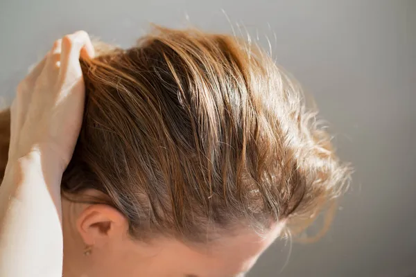 La donna mostra le radici cresciute di capelli grigi. vernice per capelli grigi. — Foto Stock