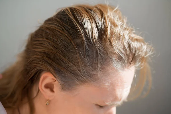 La donna mostra le radici cresciute di capelli grigi. vernice per capelli grigi. — Foto Stock