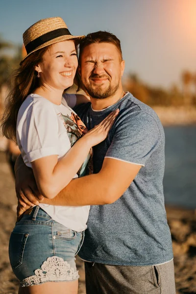 Sol brilhante. um homem e uma mulher apaixonados a espreitar do abraço de sol na praia. — Fotografia de Stock