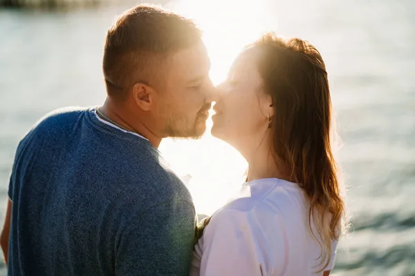 Profili coppia innamorata baciare sulla spiaggia del mare. abbagliamento solare — Foto Stock