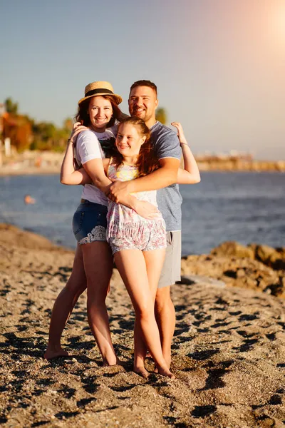 Счастливая семья на пляже. мама, папа и дочь в отпуске на морском курорте. — стоковое фото