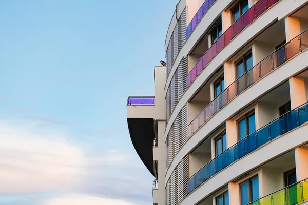 La pared de un edificio de varios pisos con balcones de vidrio multicolor — Foto de Stock